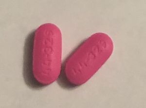 Two bright pink diphenhydramine tablets (generic form of Benadryl)