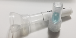 Saliva DNA collection tube with blue preservation fluid in a separate tube.